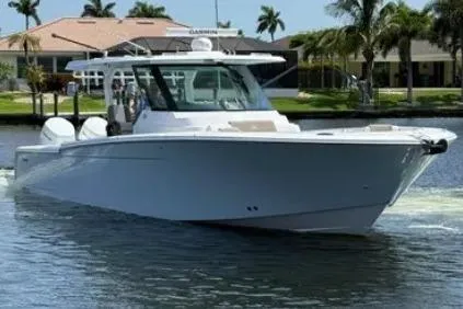  Yacht Photos Pics 2024 Bertram 39 CC boat cruising on a sunny day, surrounded by palm trees.
