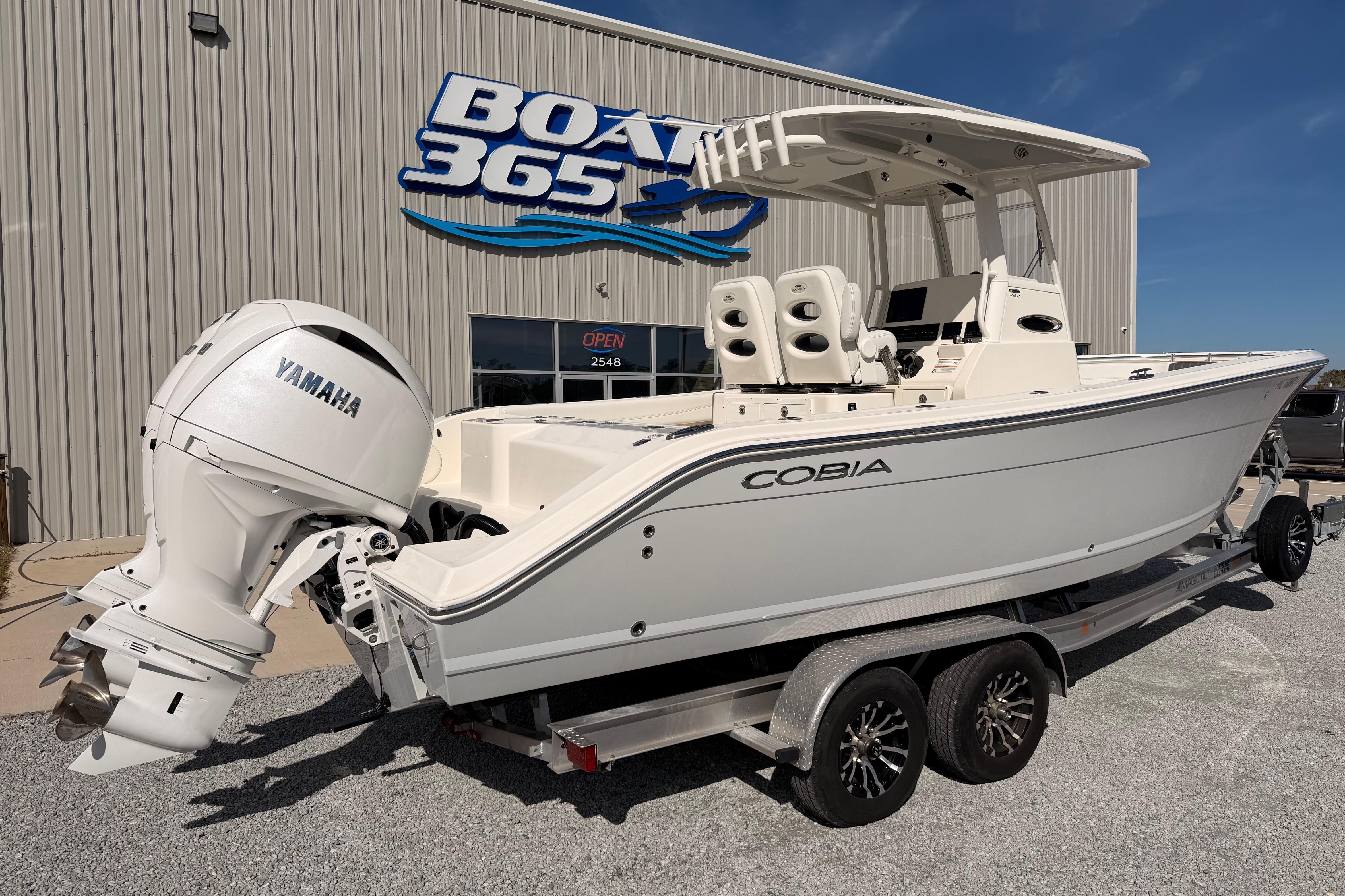 2024 Cobia 262 Center Console boat with Yamaha engine on trailer at dealership.