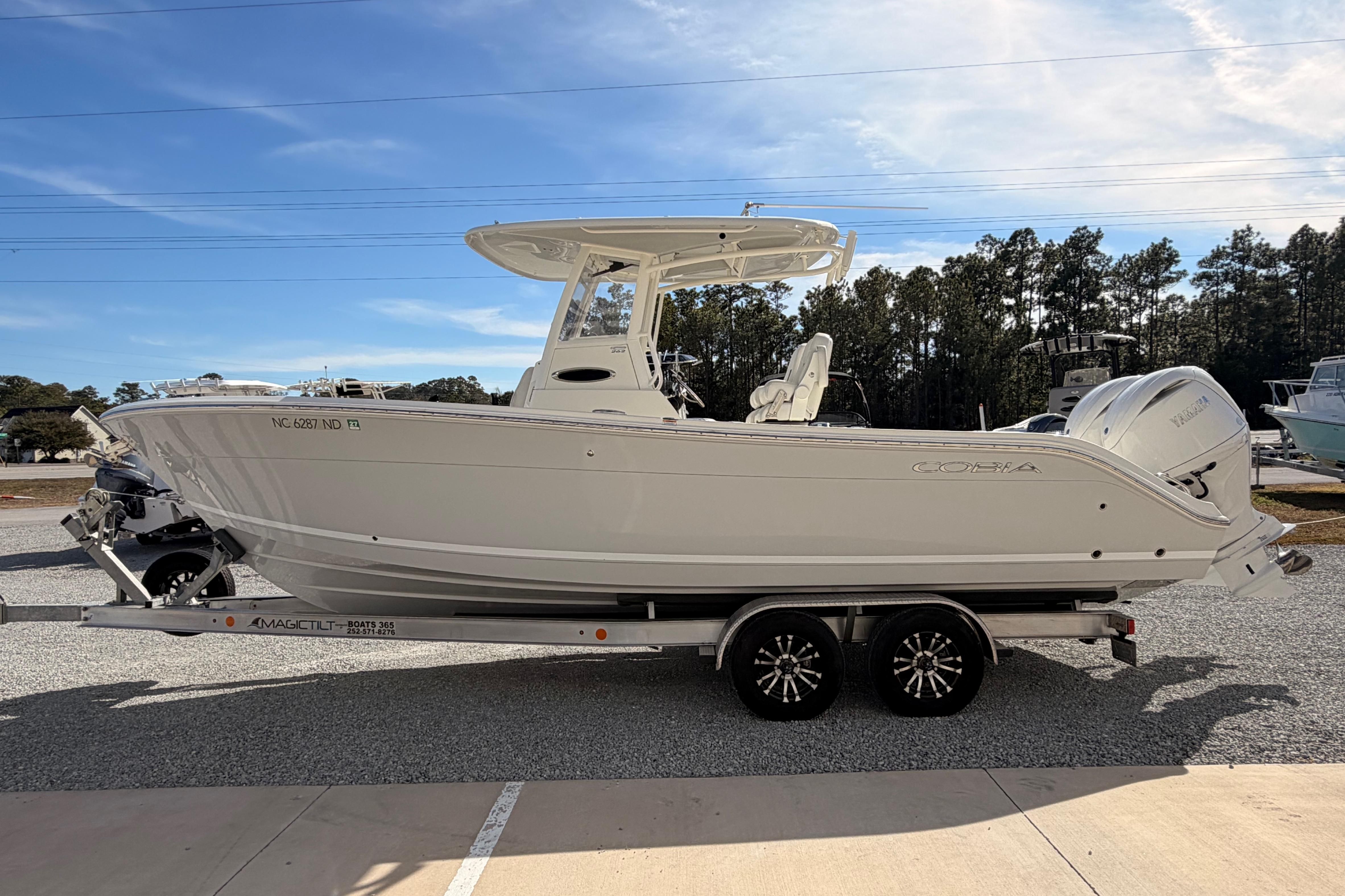 2024 Cobia 262 Center Console boat on trailer, parked outdoors under clear sky.