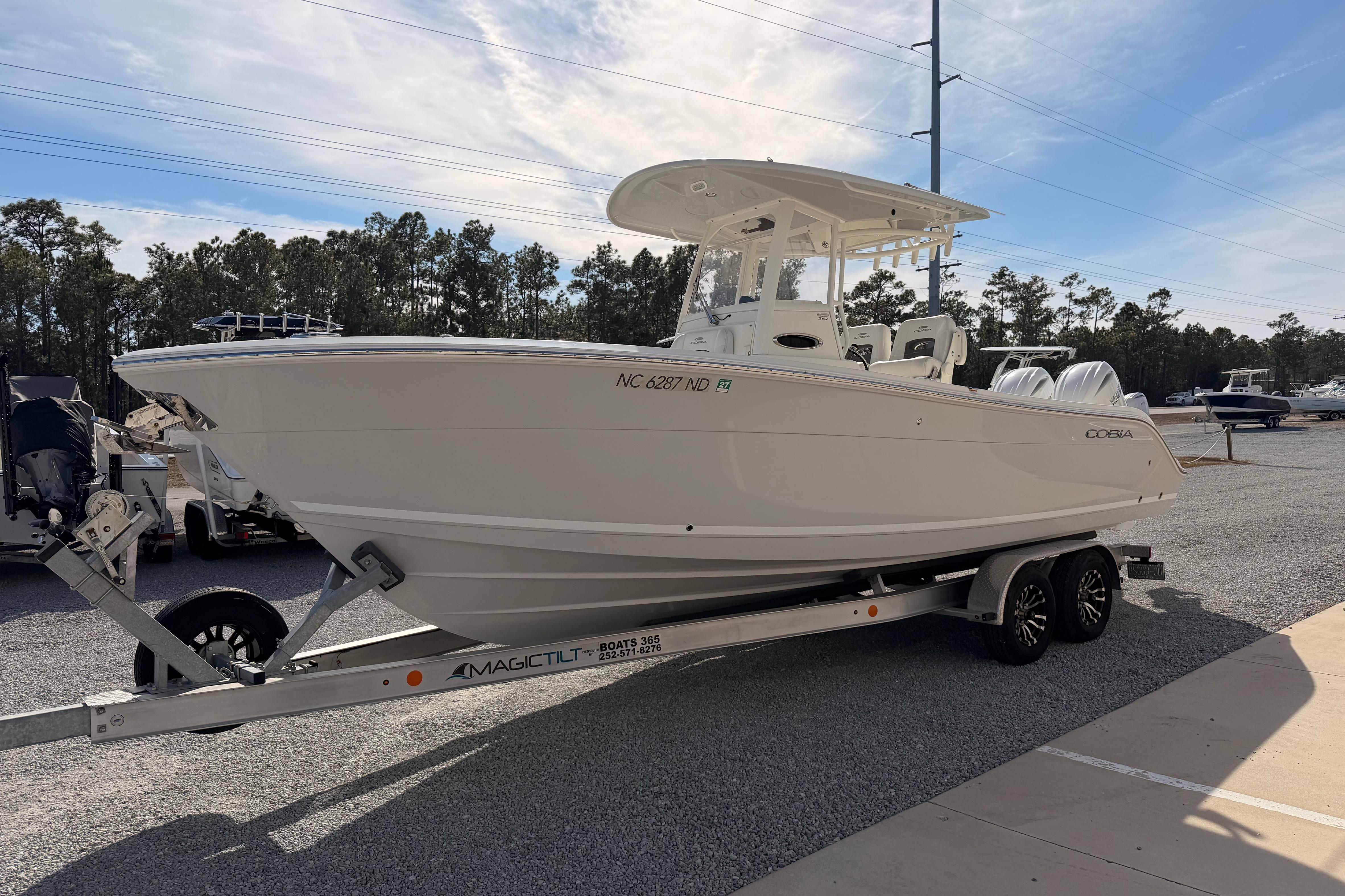 2024 Cobia 262 Center Console boat on trailer, parked outdoors under clear sky.