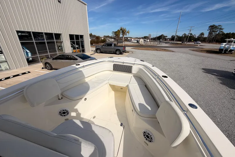  Yacht Photos Pics 2024 Cobia 262 Center Console boat with spacious seating, displayed outdoors near a showroom.