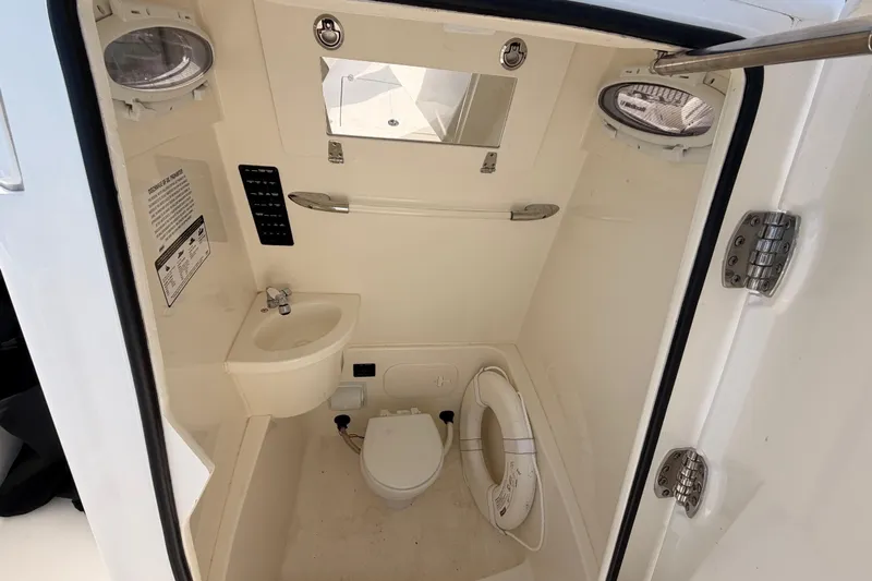  Yacht Photos Pics 2024 Cobia 262 Center Console boat interior with sink, toilet, and portholes.