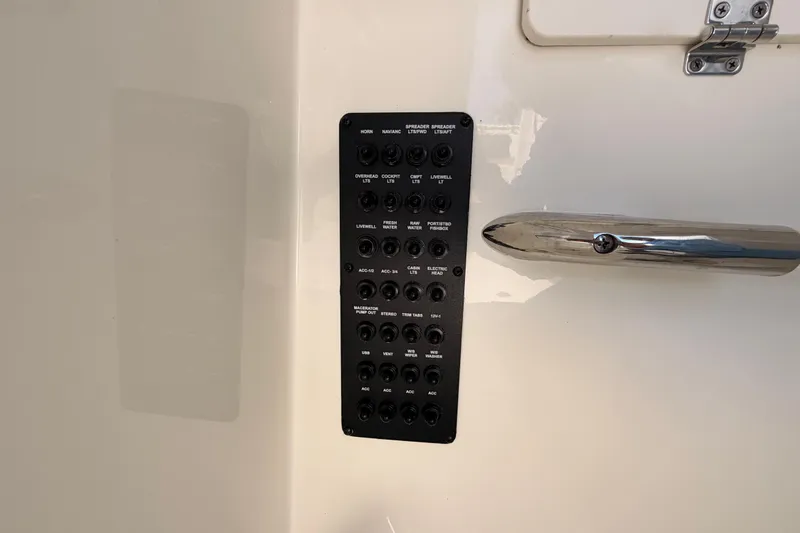  Yacht Photos Pics Control panel on 2024 Cobia 262 Center Console boat, featuring various switches and a metal cleat.