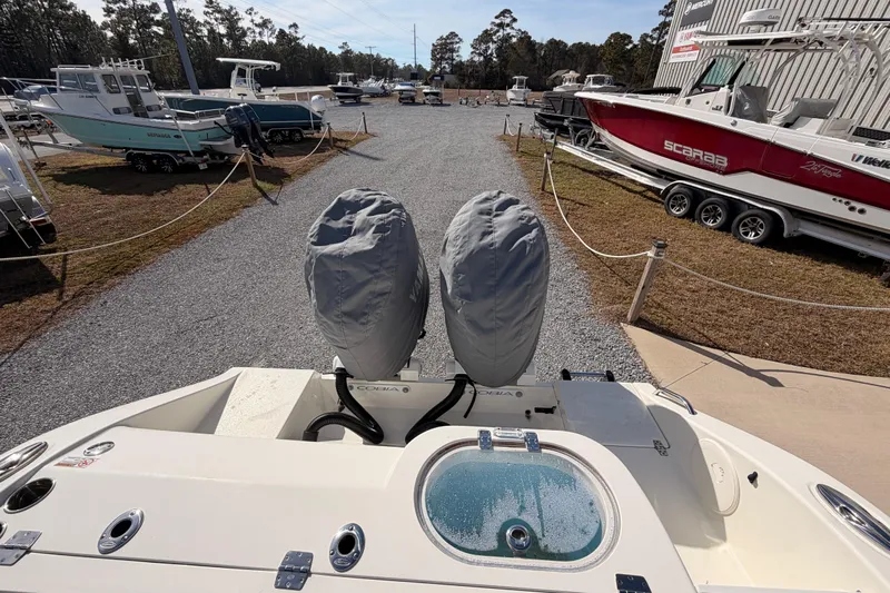  Yacht Photos Pics 2024 Cobia 262 Center Console boat with covered engines, parked in a marina.