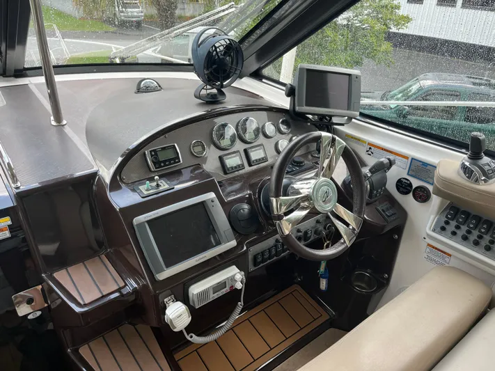  Yacht Photos Pics 2014 Regal 35 Sport Coupe cockpit with steering wheel, navigation screens, and control panel.