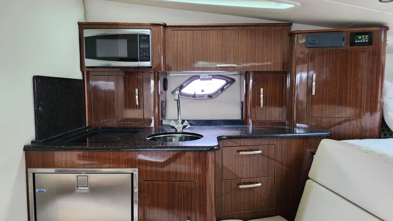  Yacht Photos Pics 2014 Regal 35 Sport Coupe interior kitchen with wood cabinetry and modern appliances.