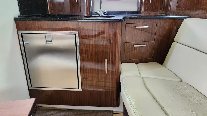  Yacht Photos Pics Interior of 2014 Regal 35 Sport Coupe with wood cabinetry and stainless steel fridge.