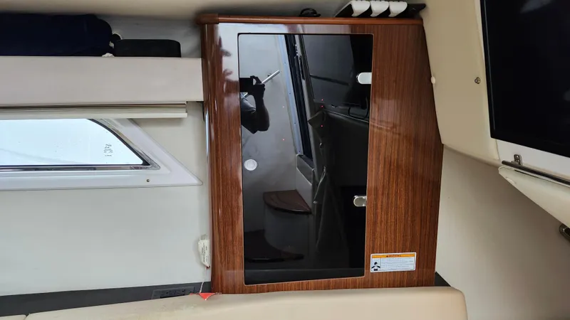  Yacht Photos Pics Interior of a 2014 Regal 35 Sport Coupe with wooden cabinetry and window view.