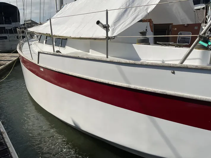  Yacht Photos Pics 1980 Kanter Staysail Cutter with red stripe, docked in marina.