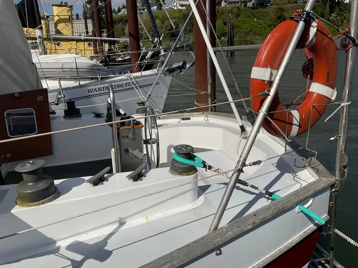  Yacht Photos Pics 1980 Kanter Staysail Cutter with lifebuoy, docked in a marina.