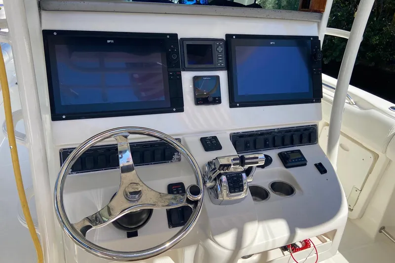  Yacht Photos Pics Control panel of a 2011 Boston Whaler 320 Outrage boat with dual screens and steering wheel.