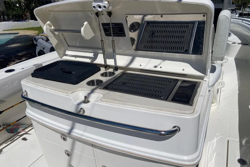  Yacht Photos Pics 2011 Boston Whaler 320 Outrage boat grill station with storage and cup holders.