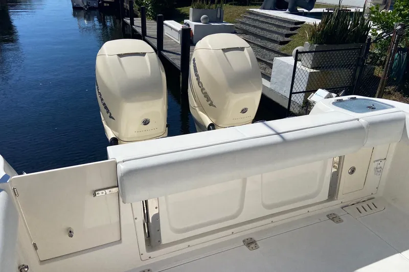  Yacht Photos Pics 2011 Boston Whaler 320 Outrage with twin Mercury outboard engines docked by the water.