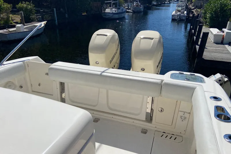 Yacht Photos Pics 2011 Boston Whaler 320 Outrage boat with twin outboard engines docked in a canal.