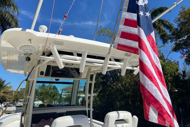  Yacht Photos Pics 2011 Boston Whaler 320 Outrage boat with American flag, sunny day, palm trees.