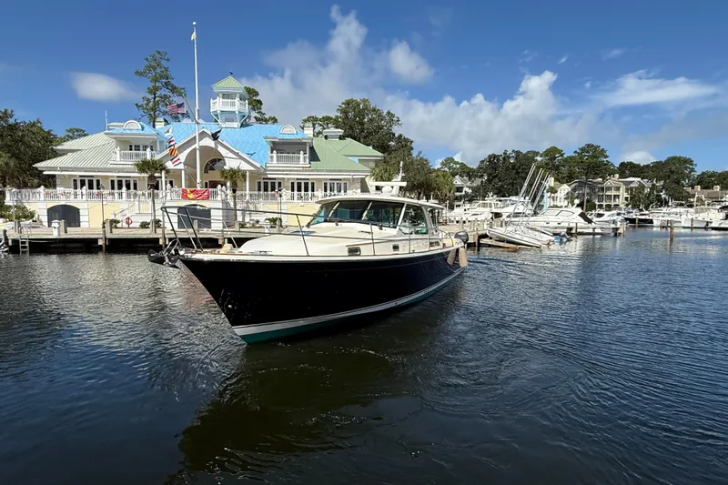 Strange Magic Yacht Photos Pics 2023 Sabre 43 Salon Express yacht docked at a marina with scenic background.