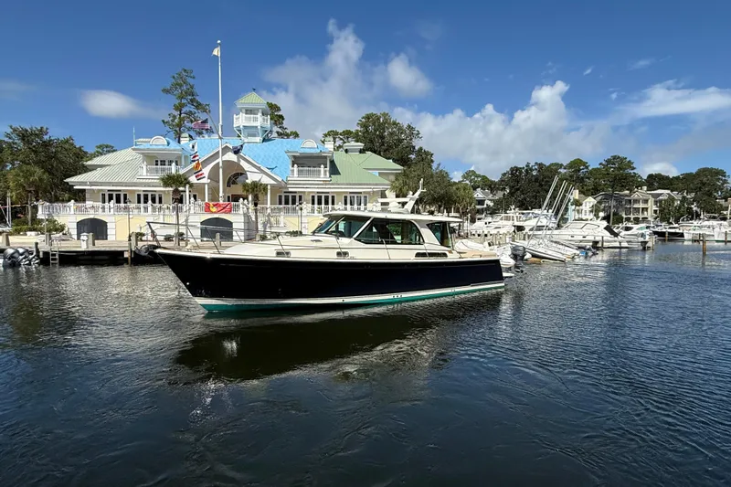 Strange Magic Yacht Photos Pics 2023 Sabre 43 Salon Express yacht docked at a marina with scenic background.