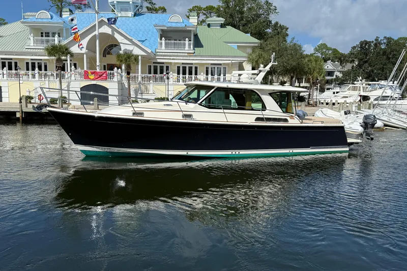 Strange Magic Yacht Photos Pics 2023 Sabre 43 Salon Express yacht docked at a marina with elegant architecture.