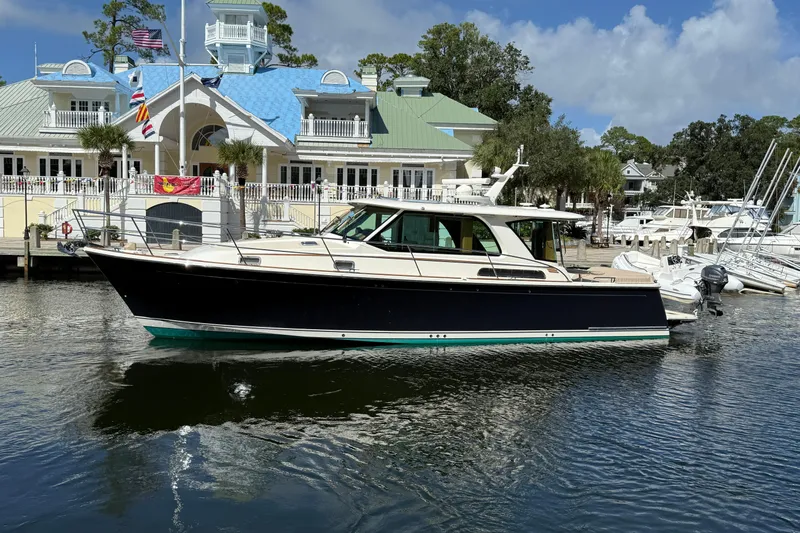 Strange Magic Yacht Photos Pics 2023 Sabre 43 Salon Express yacht docked at a marina with a scenic backdrop.
