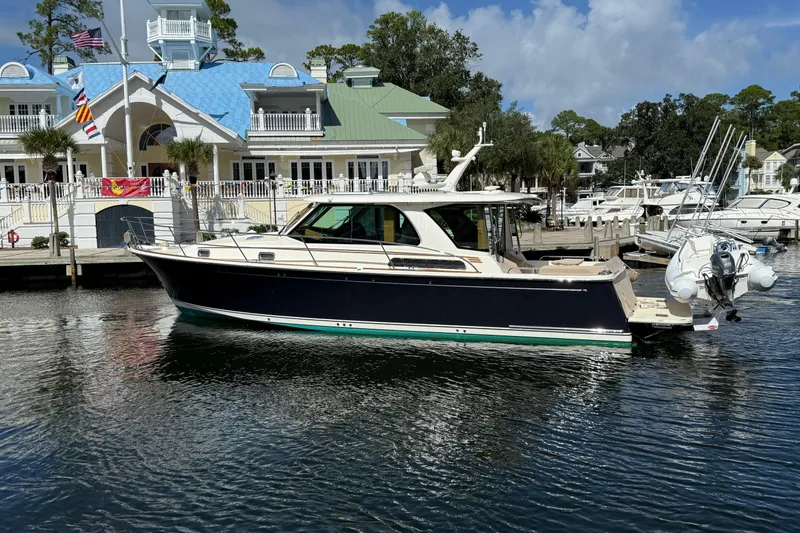 Strange Magic Yacht Photos Pics 2023 Sabre 43 Salon Express yacht docked at a marina with a scenic backdrop.