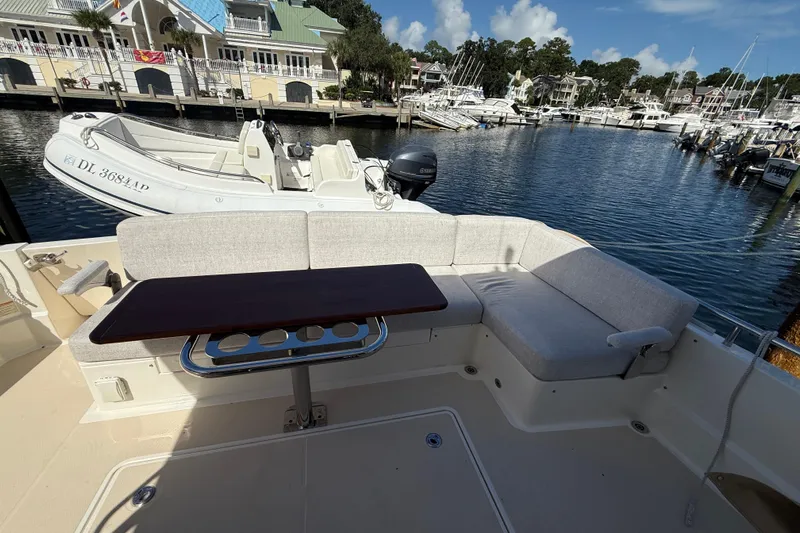 Strange Magic Yacht Photos Pics 2023 Sabre 43 Salon Express yacht with outdoor seating and table, docked at marina.