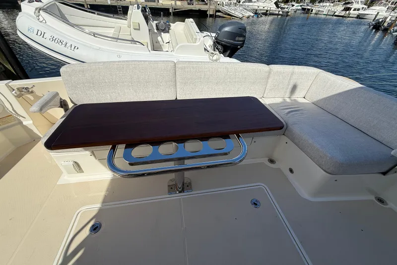 Strange Magic Yacht Photos Pics 2023 Sabre 43 Salon Express yacht interior with cushioned seating and wooden table.
