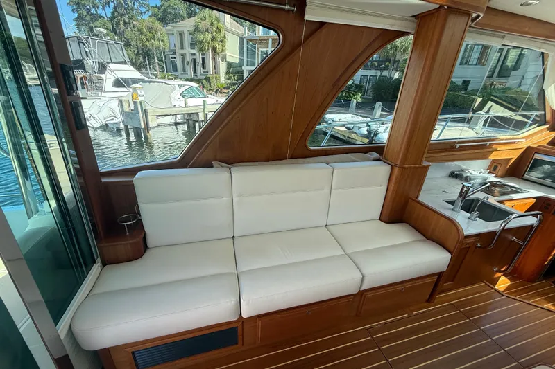 Strange Magic Yacht Photos Pics Interior of 2023 Sabre 43 Salon Express yacht with white seating and wooden accents.