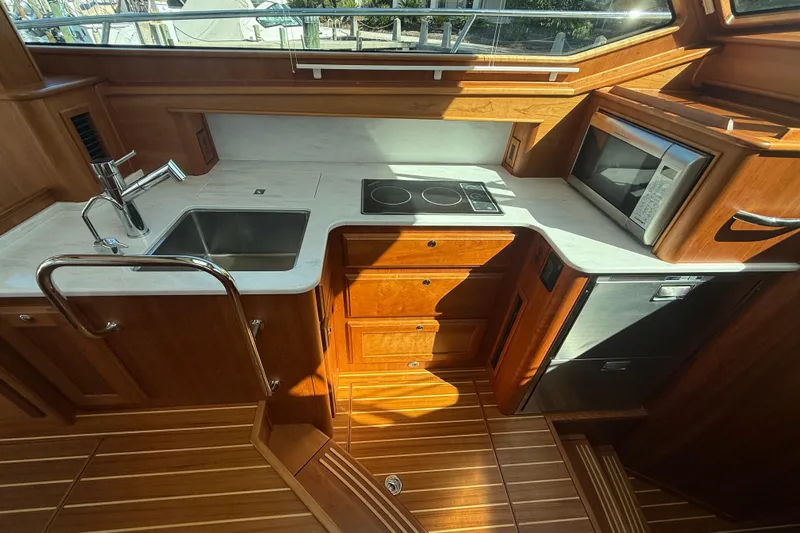 Strange Magic Yacht Photos Pics Luxurious 2023 Sabre 43 Salon Express yacht kitchen with modern appliances and wooden cabinetry.