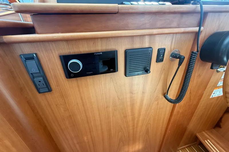 Strange Magic Yacht Photos Pics 2023 Sabre 43 Salon Express dashboard with Fusion and Garmin controls, wood finish.