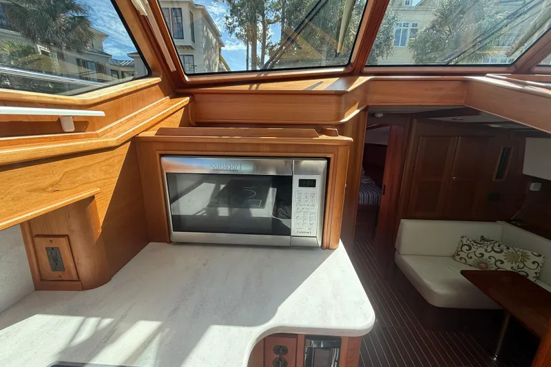 Strange Magic Yacht Photos Pics 2023 Sabre 43 Salon Express interior with microwave, wood finish, and seating area.