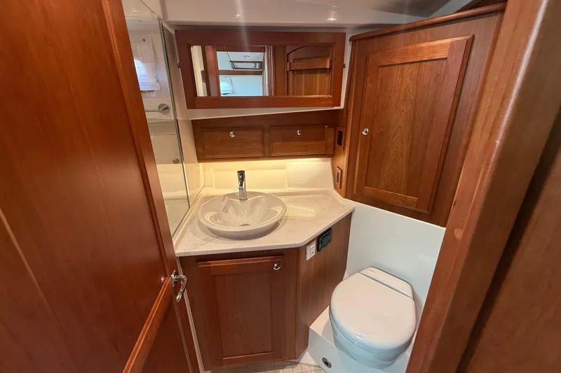 Strange Magic Yacht Photos Pics Luxurious 2023 Sabre 43 Salon Express bathroom with wooden cabinetry and modern fixtures.