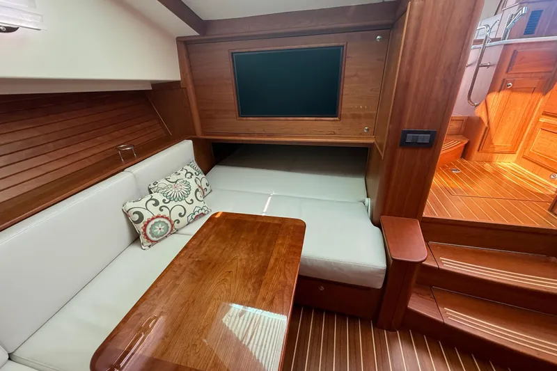 Strange Magic Yacht Photos Pics 2023 Sabre 43 Salon Express interior with wooden finish and cozy seating area.