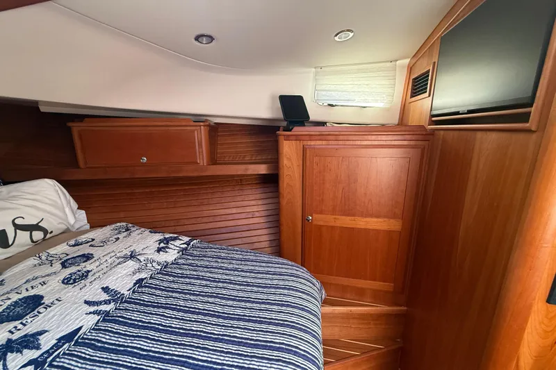 Strange Magic Yacht Photos Pics 2023 Sabre 43 Salon Express cabin with wood paneling and cozy bedding.