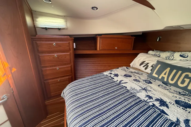 Strange Magic Yacht Photos Pics 2023 Sabre 43 Salon Express cabin with wooden cabinetry and cozy bedding.