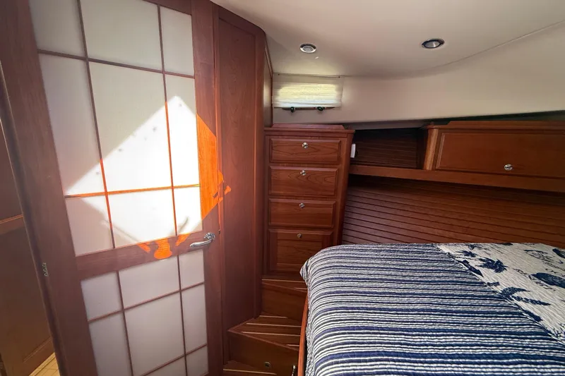 Strange Magic Yacht Photos Pics Luxurious 2023 Sabre 43 Salon Express cabin with elegant wood cabinetry and cozy bedding.