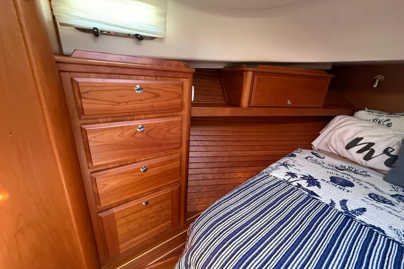 Strange Magic Yacht Photos Pics 2023 Sabre 43 Salon Express cabin with wooden cabinetry and cozy bedding.