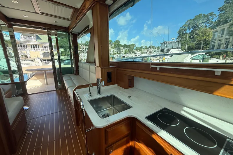 Strange Magic Yacht Photos Pics Interior of 2023 Sabre 43 Salon Express yacht with modern kitchen and scenic marina view.