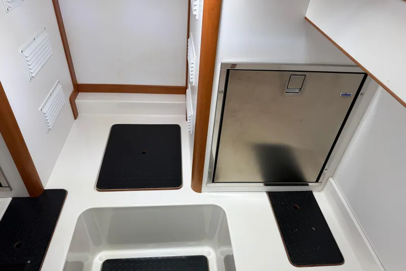 Strange Magic Yacht Photos Pics 2023 Sabre 43 Salon Express interior with stainless steel door and black floor mats.