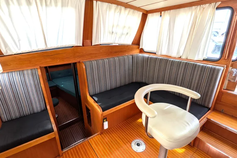 Firefly Yacht Photos Pics Interior of 1985 Siltala Nauticat 44 yacht with striped seating and wooden finishes.