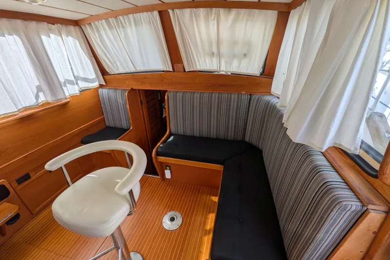 Firefly Yacht Photos Pics Interior of 1985 Siltala Nauticat 44 yacht with striped seating and wooden accents.