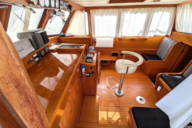Firefly Yacht Photos Pics Interior of 1985 Siltala Nauticat 44 yacht with wooden helm and seating area.