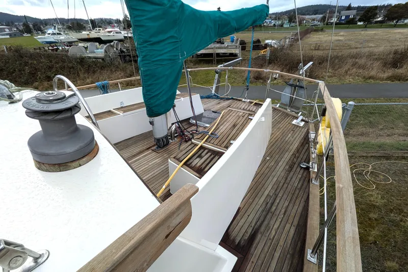 Firefly Yacht Photos Pics 1985 Siltala Nauticat 44 sailboat deck with wooden flooring and green sail cover.