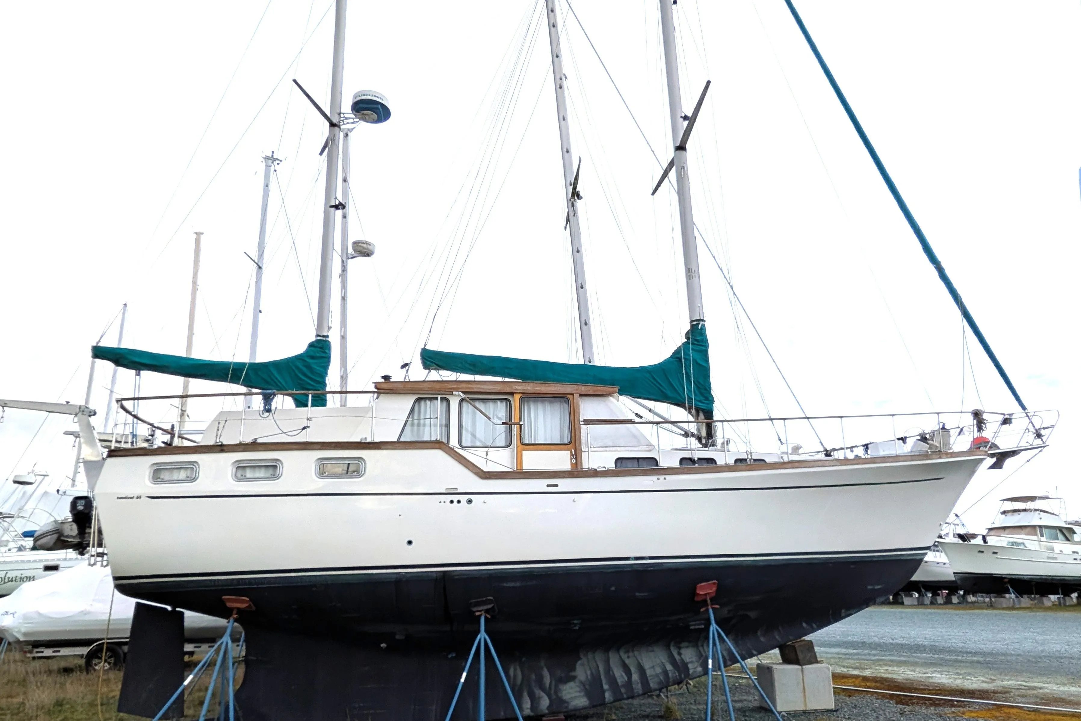 1985 Siltala Nauticat 44 sailboat on stands, with green covers, in a boatyard.