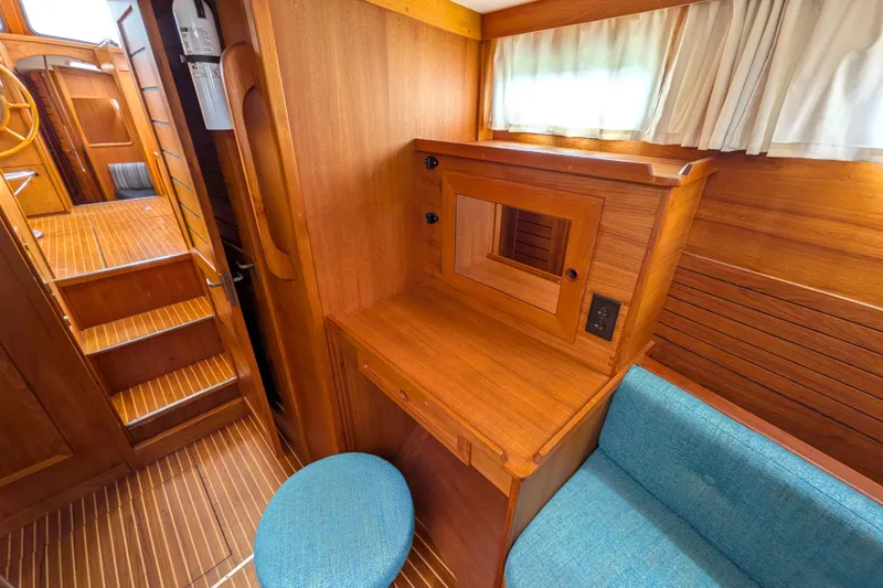 Firefly Yacht Photos Pics Interior of 1985 Siltala Nauticat 44 yacht with wooden desk and blue stool.