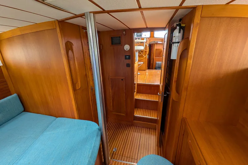 Firefly Yacht Photos Pics Interior of 1985 Siltala Nauticat 44 yacht with wooden finish and blue seating.