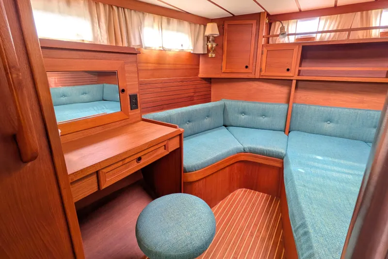 Firefly Yacht Photos Pics Cozy interior of 1985 Siltala Nauticat 44 yacht with wooden furnishings and teal seating.