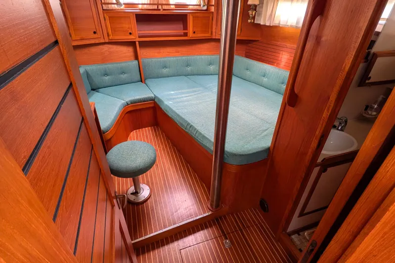 Firefly Yacht Photos Pics Cozy interior of 1985 Siltala Nauticat 44 yacht with teal seating and wooden finish.