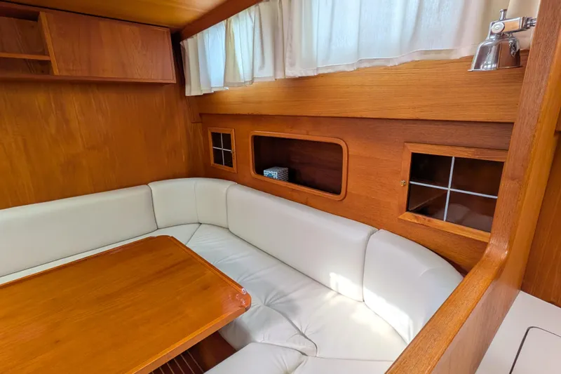 Firefly Yacht Photos Pics Interior of 1985 Siltala Nauticat 44 yacht with white seating and wooden accents.