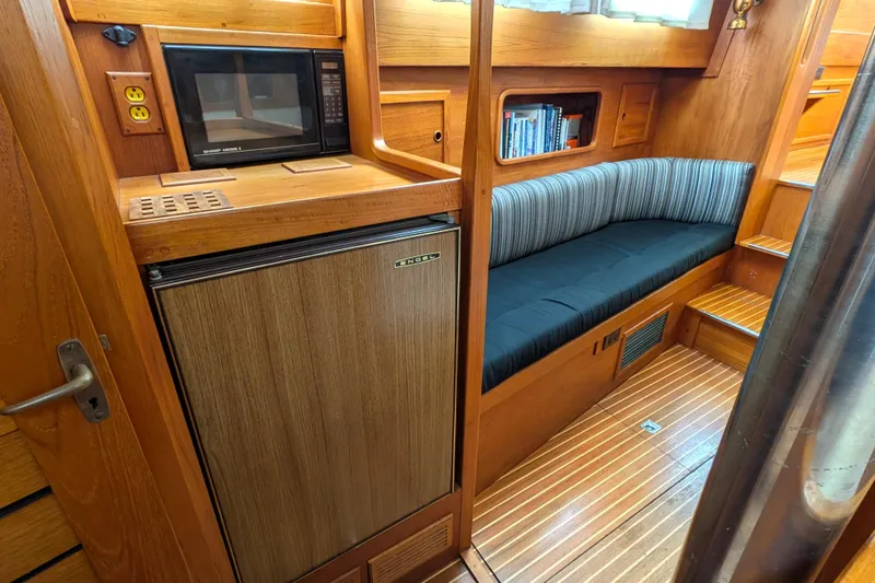 Firefly Yacht Photos Pics Interior of 1985 Siltala Nauticat 44 yacht with wood finish, microwave, and seating area.
