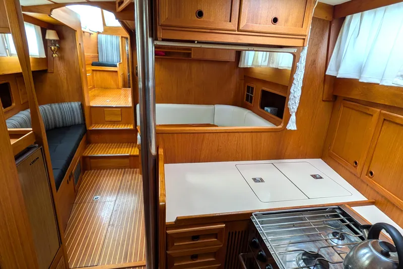 Firefly Yacht Photos Pics Interior of 1985 Siltala Nauticat 44 yacht, featuring wood paneling and compact kitchen area.